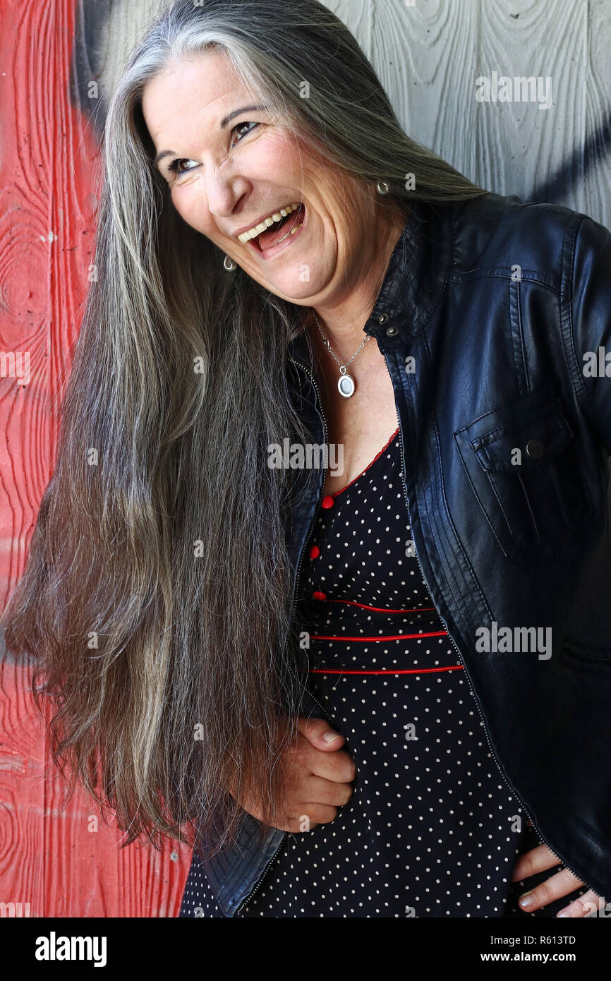 Una risa ruidosa mujer mayor con pelo largo gris Fotografía de stock - Alamy