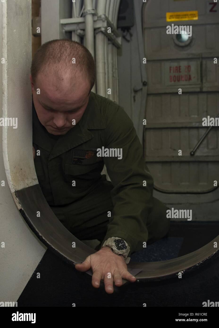 ATANTIC OCEAN (Nov. 21, 2018) Cpl. Eric Hohs, asignadas a los patriotas de Aviación Marina Escuadrón de Logística (MALS) 26, pule un umbral durante las estaciones de limpieza a bordo de la clase Wasp buque de asalto anfibio USS Iwo Jima (LHD 7) El 21 de noviembre, 2018. Iwo Jima es actualmente en curso después de participar en la coyuntura de Trident 2018 que es un ejercicio de la OTAN destinado a certificar las fuerzas de respuesta de la OTAN y la mejora de la interoperatividad entre los aliados de la OTAN y los países socios. Foto de stock