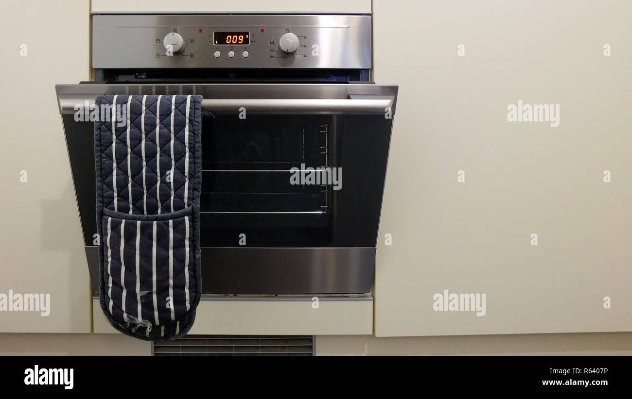 Un horno eléctrico instalado en un armario blanco, con la puerta abierta.  El horno se apaga la luz Fotografía de stock - Alamy