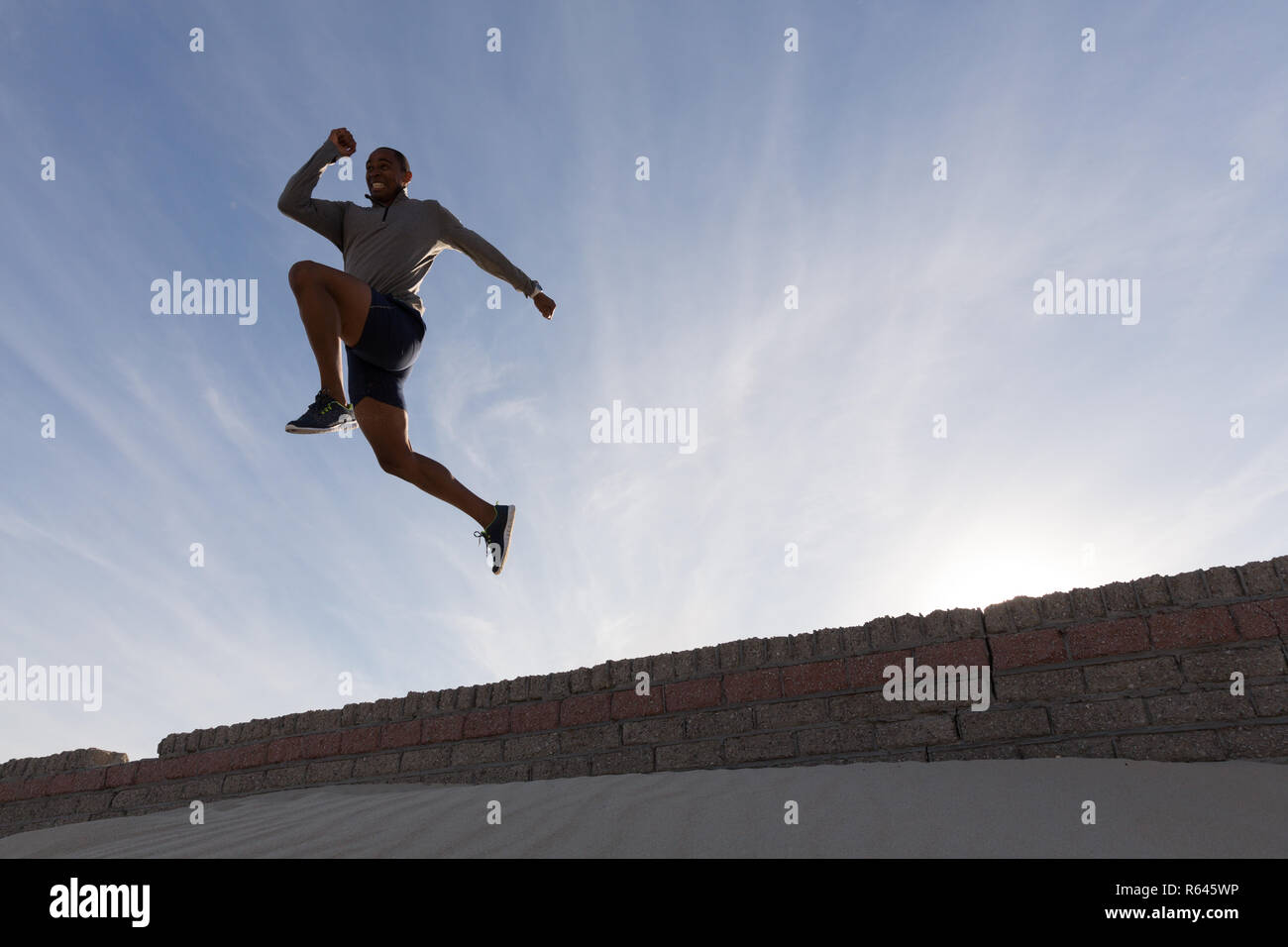 Atleta Masculino saltando de un muro circundante Foto de stock