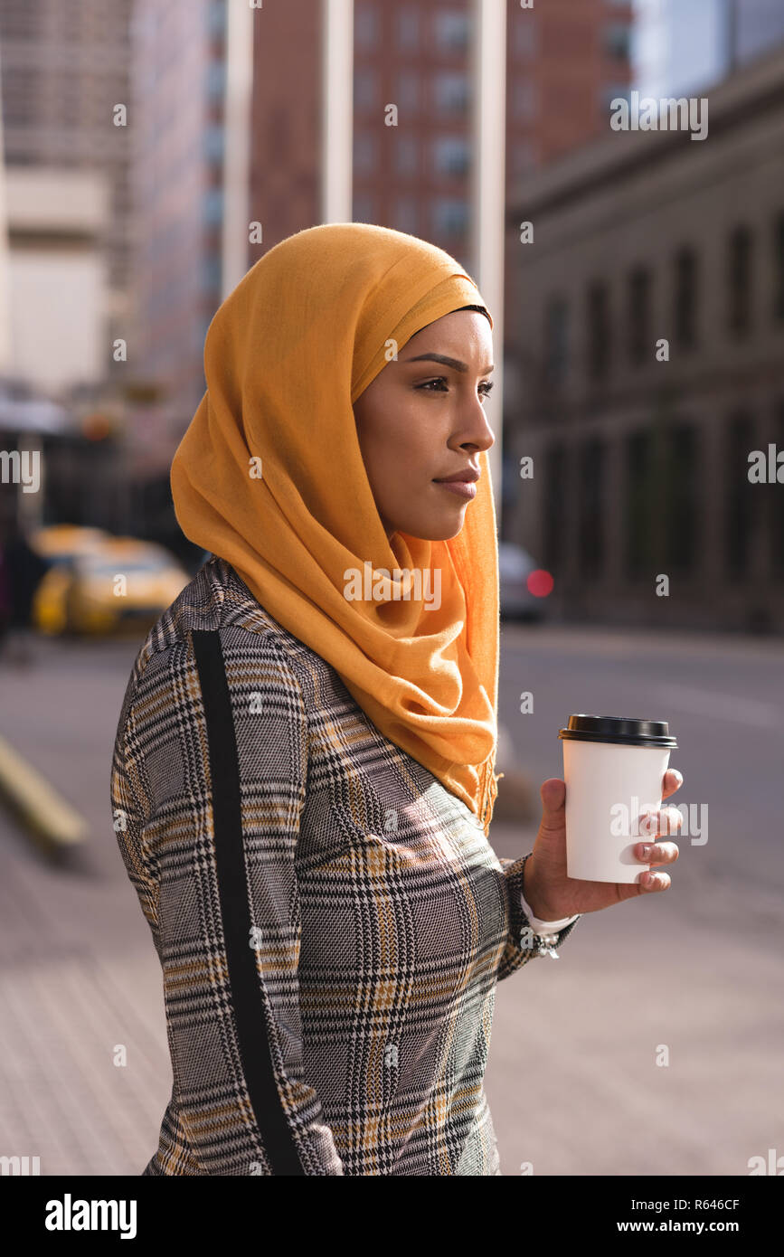 Mujer con café en las calles de la ciudad Foto de stock