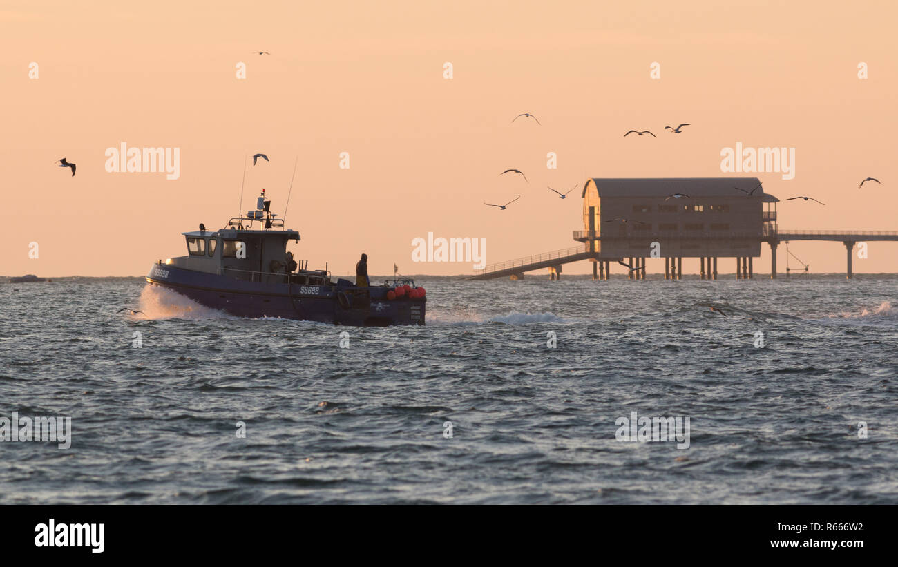 Un barco de pesca que sale del puerto de Bembridge en Sunrise cerca de St, Helen's, Isla de Wight Foto de stock