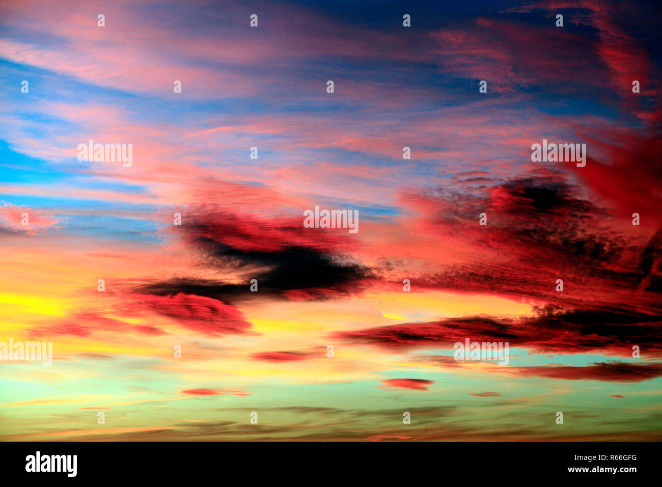 Rojo, rosa, naranja, amarillo, azul cielo, nubes, nubes, luz del atardecer, cálido, color, colorido, cielos, de formación, de las formaciones espectaculares, Inglaterra, Reino Unido. Foto de stock