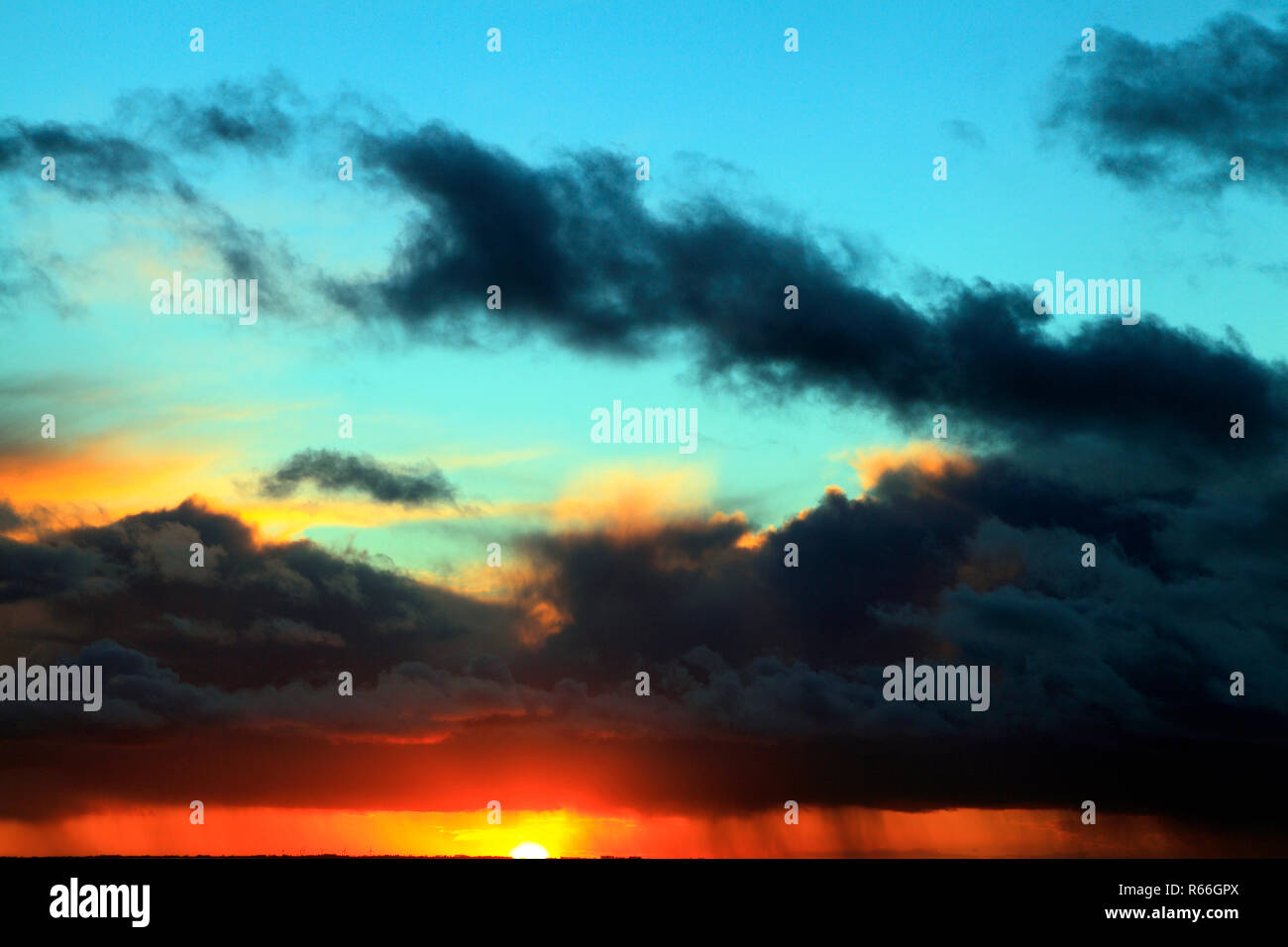 Puesta de sol, rojo, azul, rosa, cielo, nubes negras, tormenta, clima, cielo, cielo, formación, formaciones, luz del atardecer, Norfolk, Inglaterra, Reino Unido. Foto de stock
