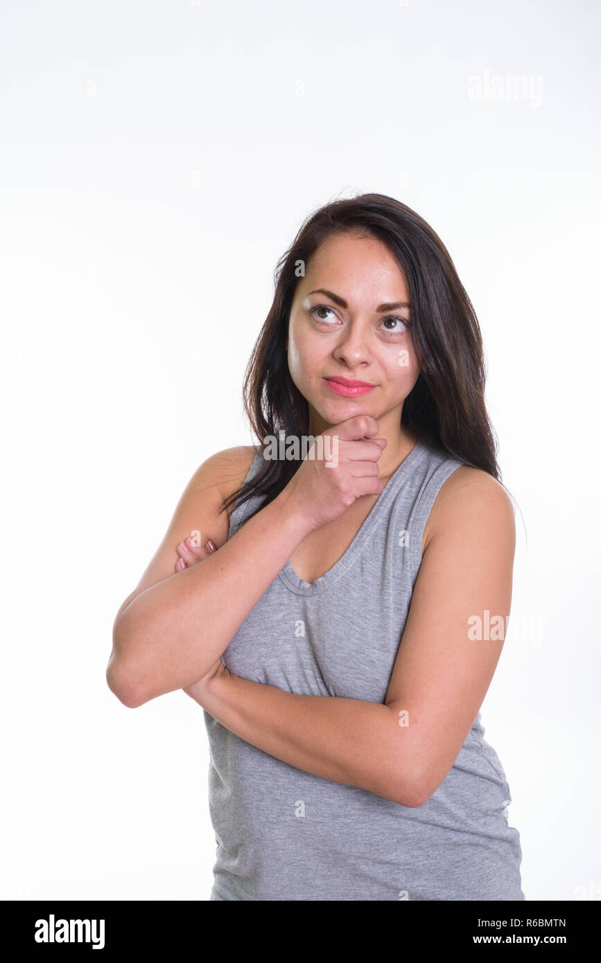 Foto de estudio de la mujer hermosa pensando con la mano en la barbilla contra Foto de stock