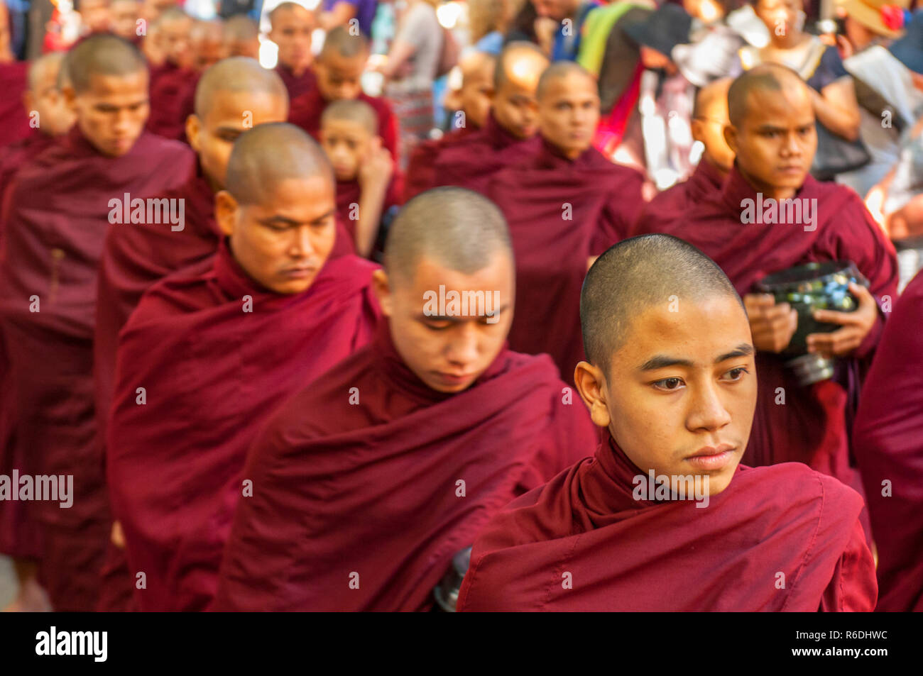 Novicios budistas caminar para recoger limosnas y ofrendas en Amarapura, cerca de Mandalay, Myanmar esta procesión se celebra cada día Foto de stock