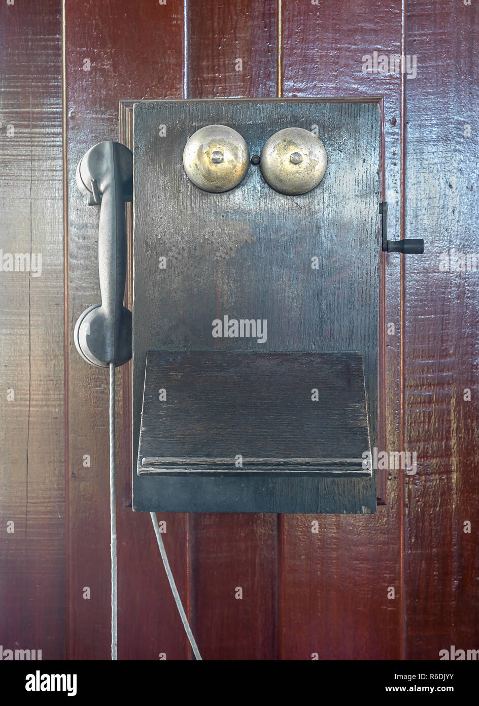 Teléfono antiguos colgar en pared de madera Foto de stock