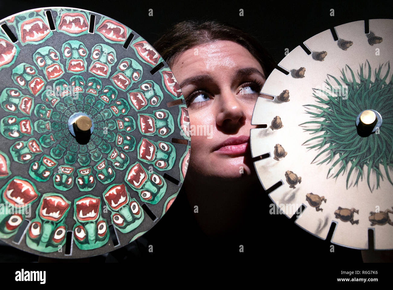 Kathryn Darcus, de la Universidad de Edimburgo, toma un vistazo a algunos discos de imagen phantasmascope victoriano que se muestran en una nueva exposición "Libros Raros : Esperar lo inesperado' en la biblioteca principal de la Universidad de Edimburgo. Foto de stock