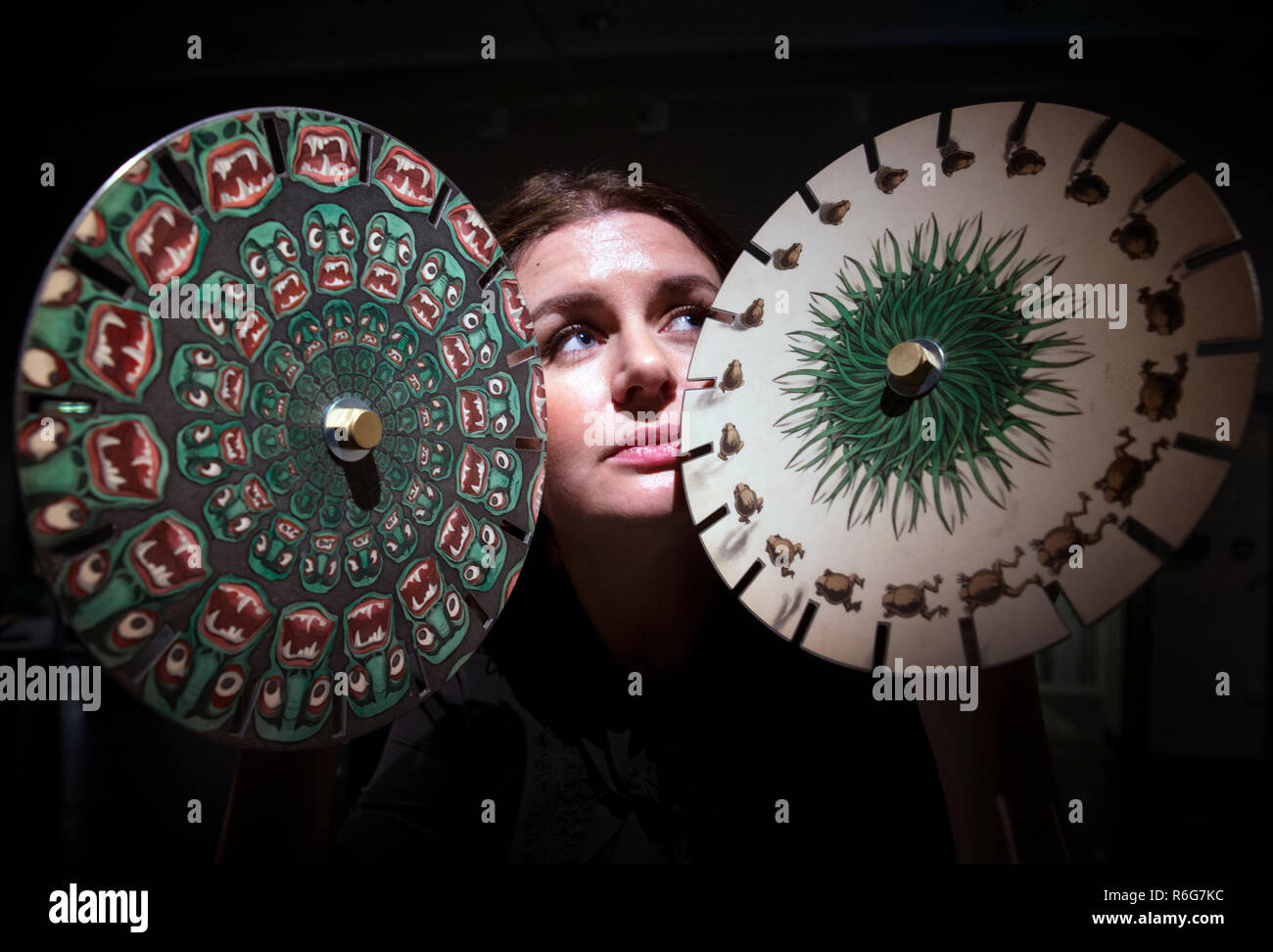 Kathryn Darcus, de la Universidad de Edimburgo, toma un vistazo a algunos discos de imagen phantasmascope victoriano que se muestran en una nueva exposición "Libros Raros : Esperar lo inesperado' en la biblioteca principal de la Universidad de Edimburgo. Foto de stock