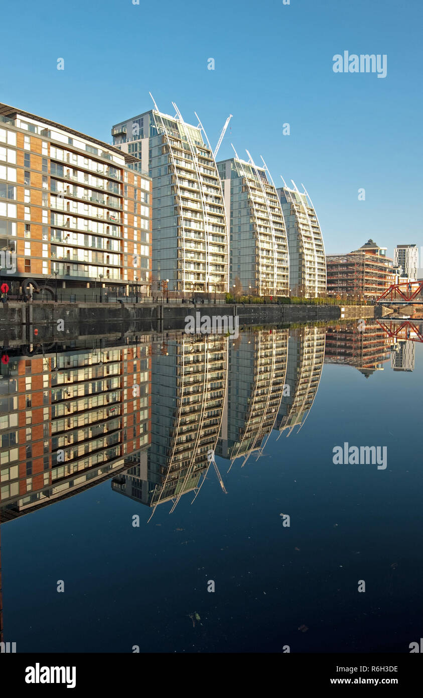 Simetría por el agua en los Muelles de Salford, cerca de Manchester, Inglaterra, como un tranquilo, soleado día de invierno crea condiciones para reflexiones casi perfecto. Foto de stock