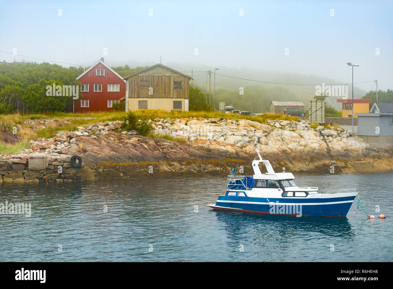 Barco cerca de la costa, con casas en Noruega Foto de stock