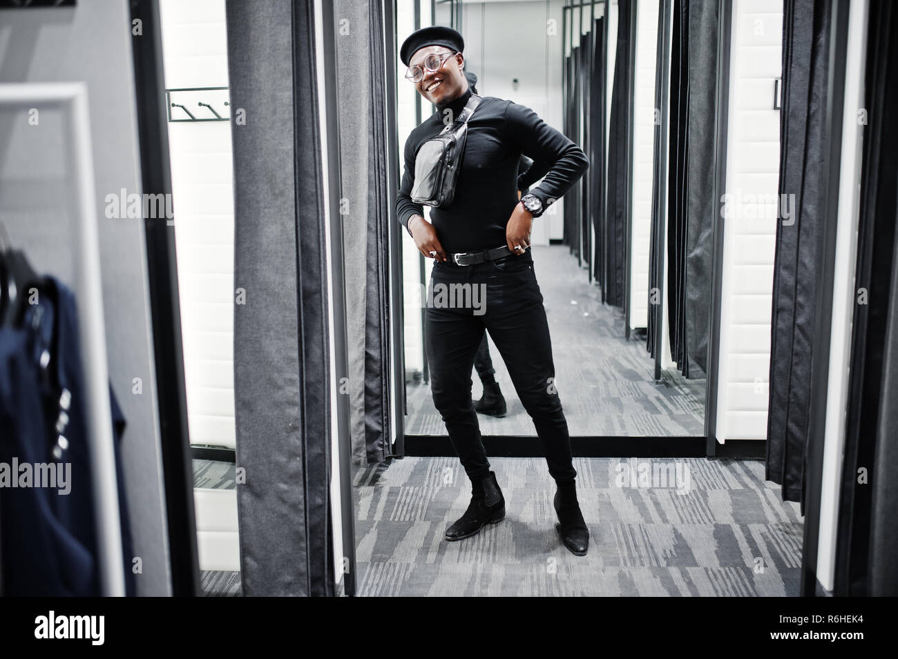 Elegante casual hombre afroamericano en traje negro y boina con cintura en  fitting room tienda ropa , mirando en el espejo Fotografía de stock - Alamy