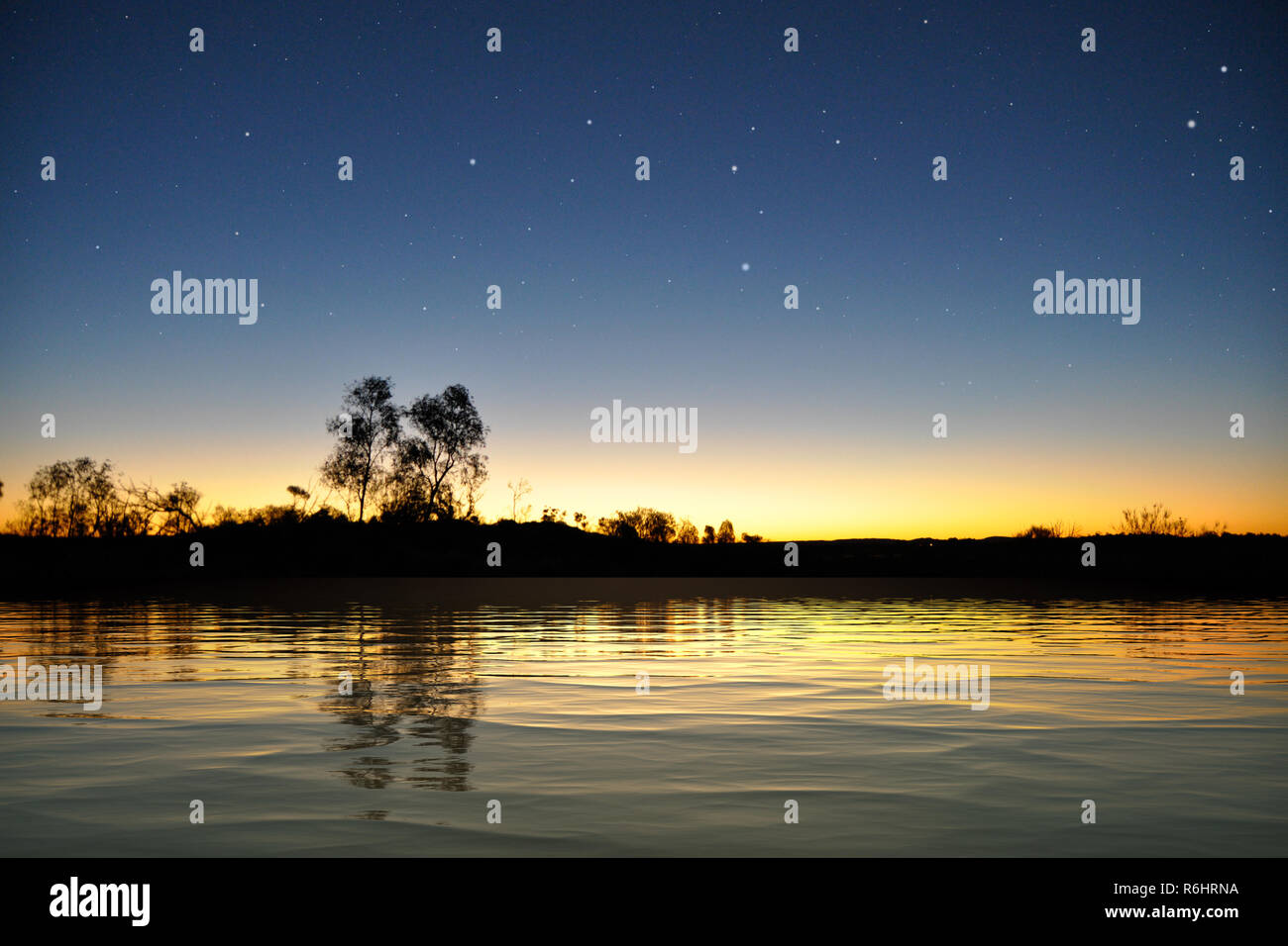 Superficie del lago después del atardecer bajo el cielo estrellado. Foto de stock