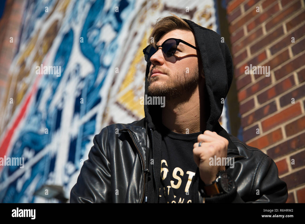 Headshots retrato de un joven apuesto atractiva y moderna moda Hombre caucásico modelado local cerca de arte al aire libre en la ciudad de Urbana en otoño invierno Foto de stock