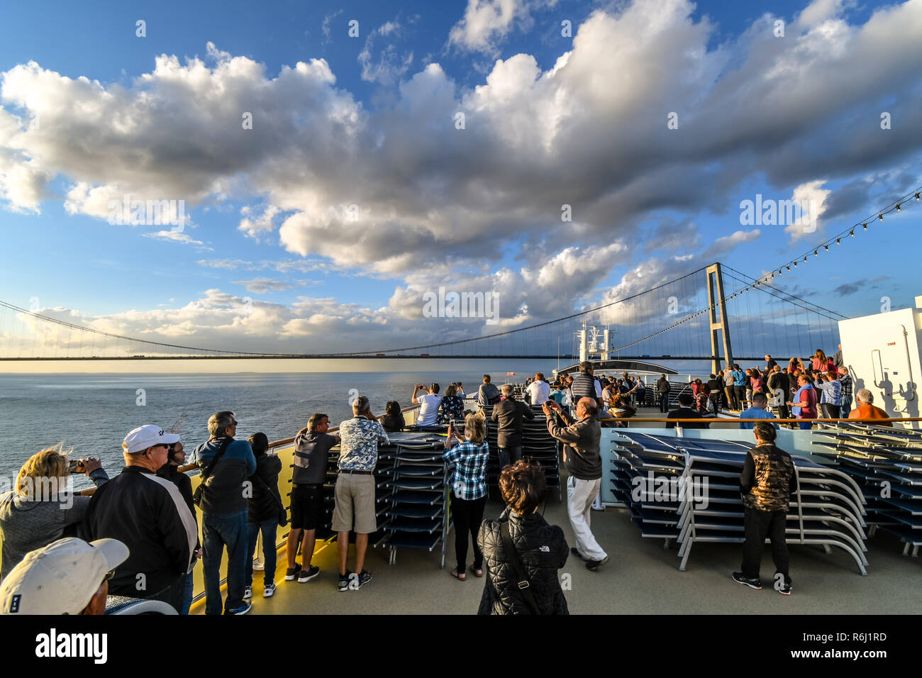 Turistas que toman fotos en la cubierta superior, como un barco de crucero se prepara para pasar bajo el puente de Oresund el estrecho entre Suecia y Dinamarca. Foto de stock