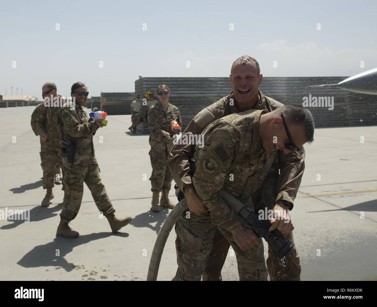 Brig. Gen. Jim Sears, comandante de la 455a ala expedicionaria aérea, lucha una manguera contra incendios lejos de el Sargento Primero en Jefe. Peter Speen, jefe del comando de la 455AEW, Fini tras completar su vuelo en aeródromo de Bagram, Afganistán, 22 de mayo de 2017. Sears, que comandaba la 455AEW durante los últimos 12 meses, es un piloto de mando con más de 3.200 horas de vuelo, incluidas misiones de combate en Irak y Afganistán. Foto de stock