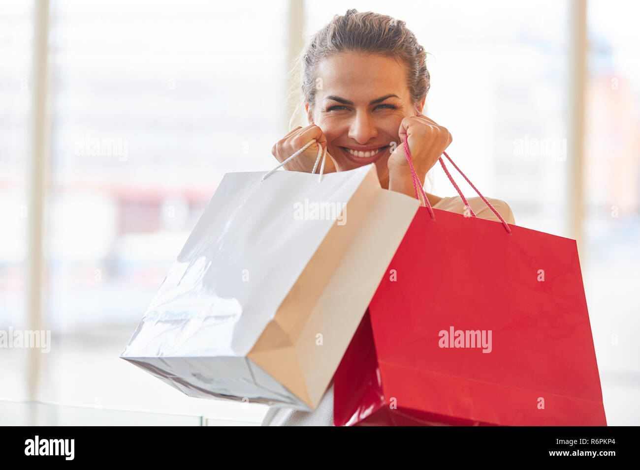 Entusiasta mujer con bolsas de compras como un símbolo de consumo y poder adquisitivo Foto de stock