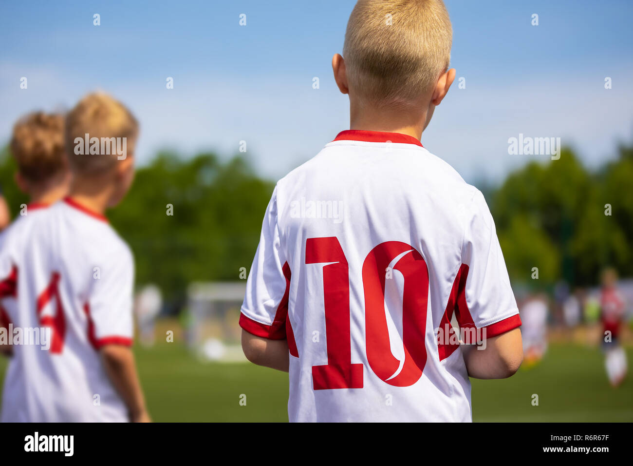 Los jóvenes jugadores de fútbol europeo caucásico esperando en la banqueta fútbol y viendo fútbol. Fútbol Juvenil imagen horizontal con fondo borroso Foto de stock
