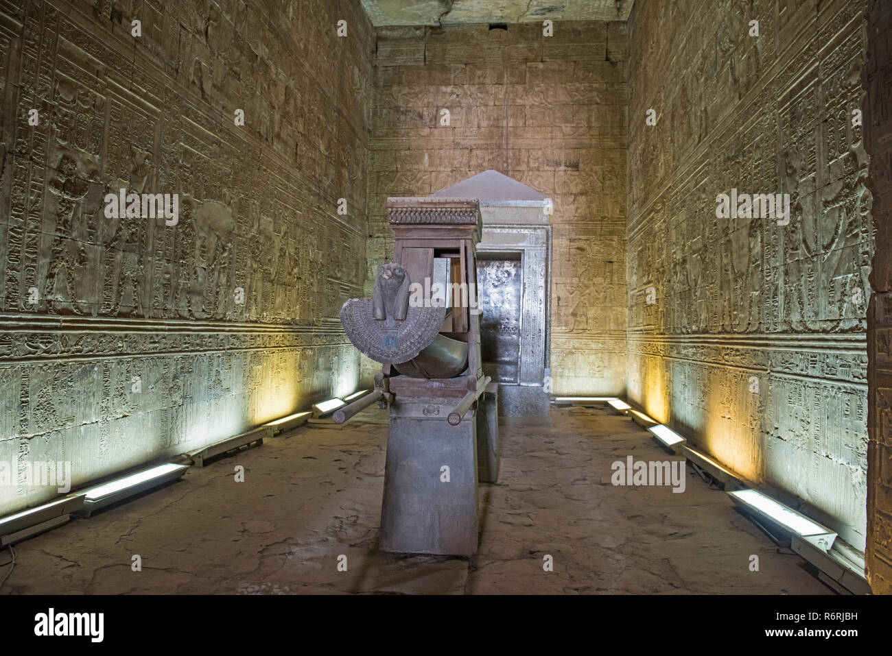 Hieroglypic tallas en la pared interior de la sala en el antiguo Egipto el templo de Horus en Edfu con barco estatua Foto de stock