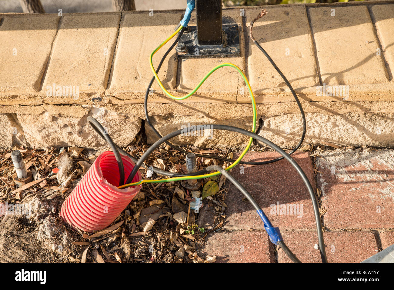 Cables eléctricos sueltos saliendo del pavimento en un parque público  Fotografía de stock - Alamy