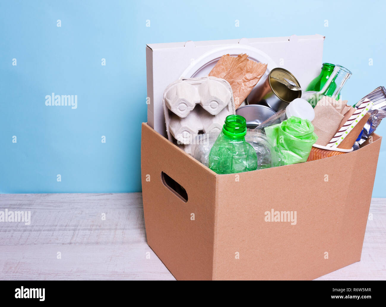 En una caja de cartón de plástico, botellas de vidrio, latas, papel. El  concepto de separar la clasificación de la basura, la protección del medio  ambiente, la ecología, la casa de reciclaje