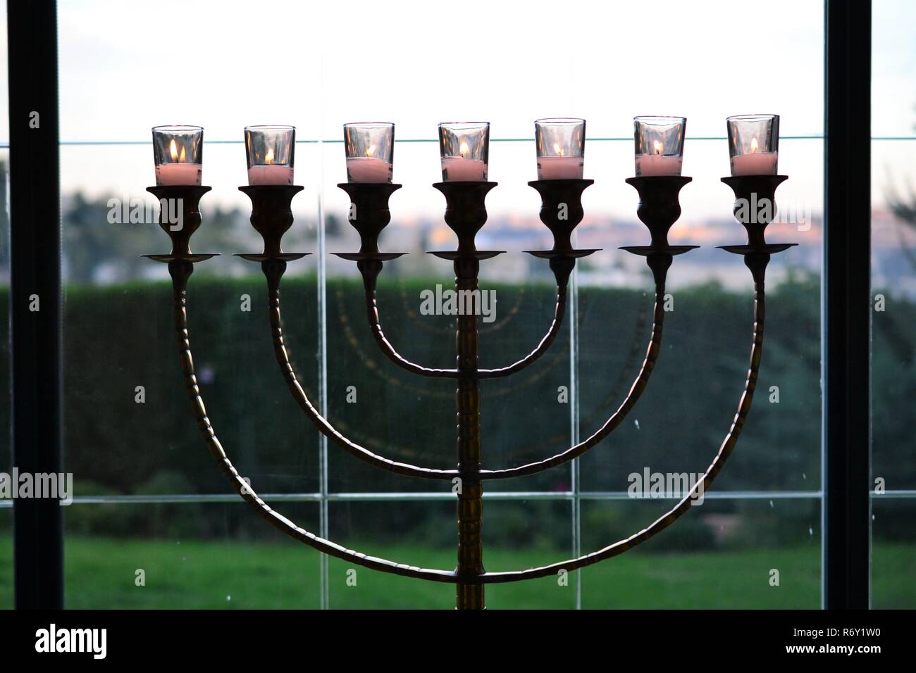 Hermosa Menorah judío armado 7 candelabro de pie en la ventana, el monte Sión en Jerusalén de fondo Foto de stock