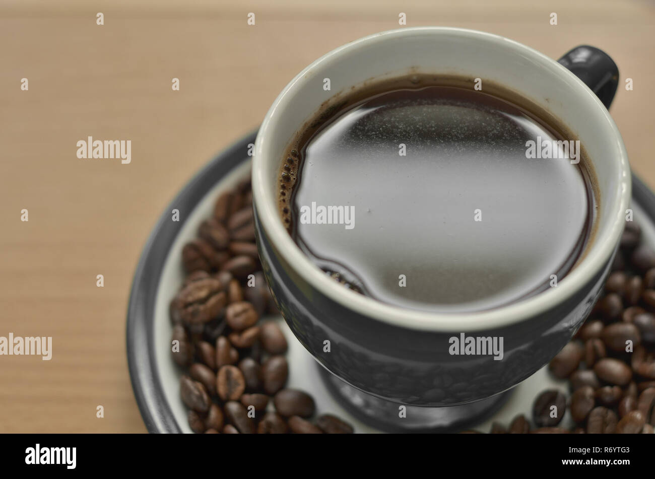 Foto de una taza de café en un platillo con granos de café. Foto de stock