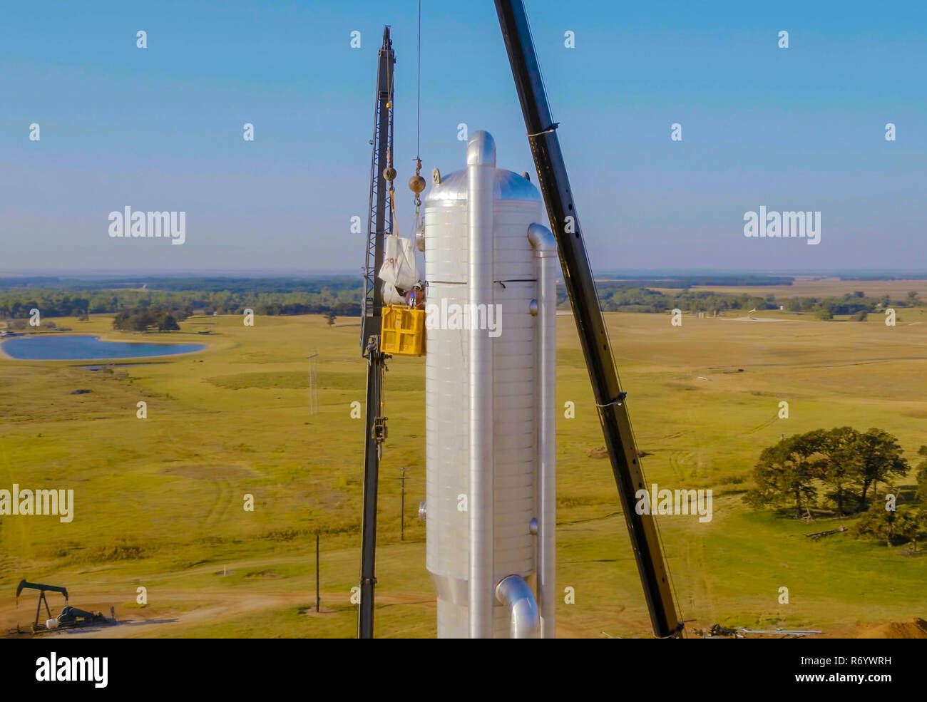 Instalación de la columna de la destilación con una grúa. La construcción de una refinería de petróleo Foto de stock