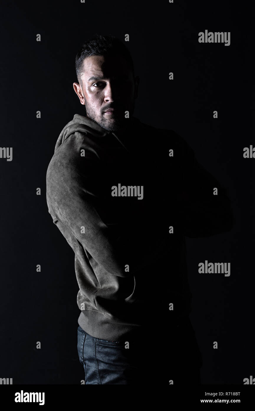 Macho con barba lleve ropa informal. Modelo de moda en ropa deportiva y  elegante. Hombre Barbado en sudadera sobre fondo oscuro. Estilo de vida  activo y saludable para el hombre. El deporte