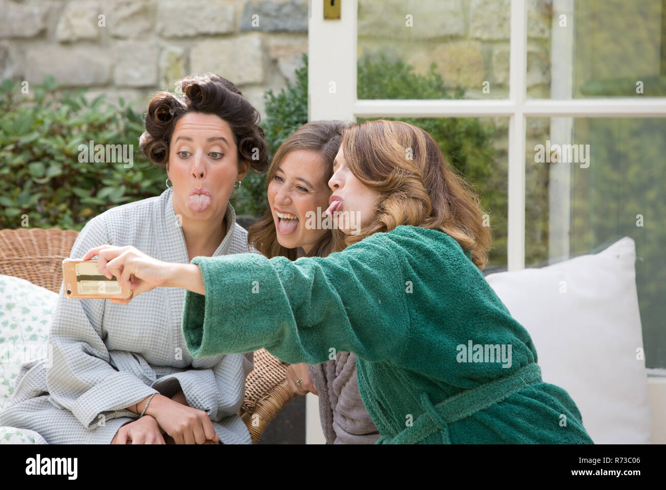 Novia y amigos tomando selfie en horas de la mañana del día de la boda Foto de stock
