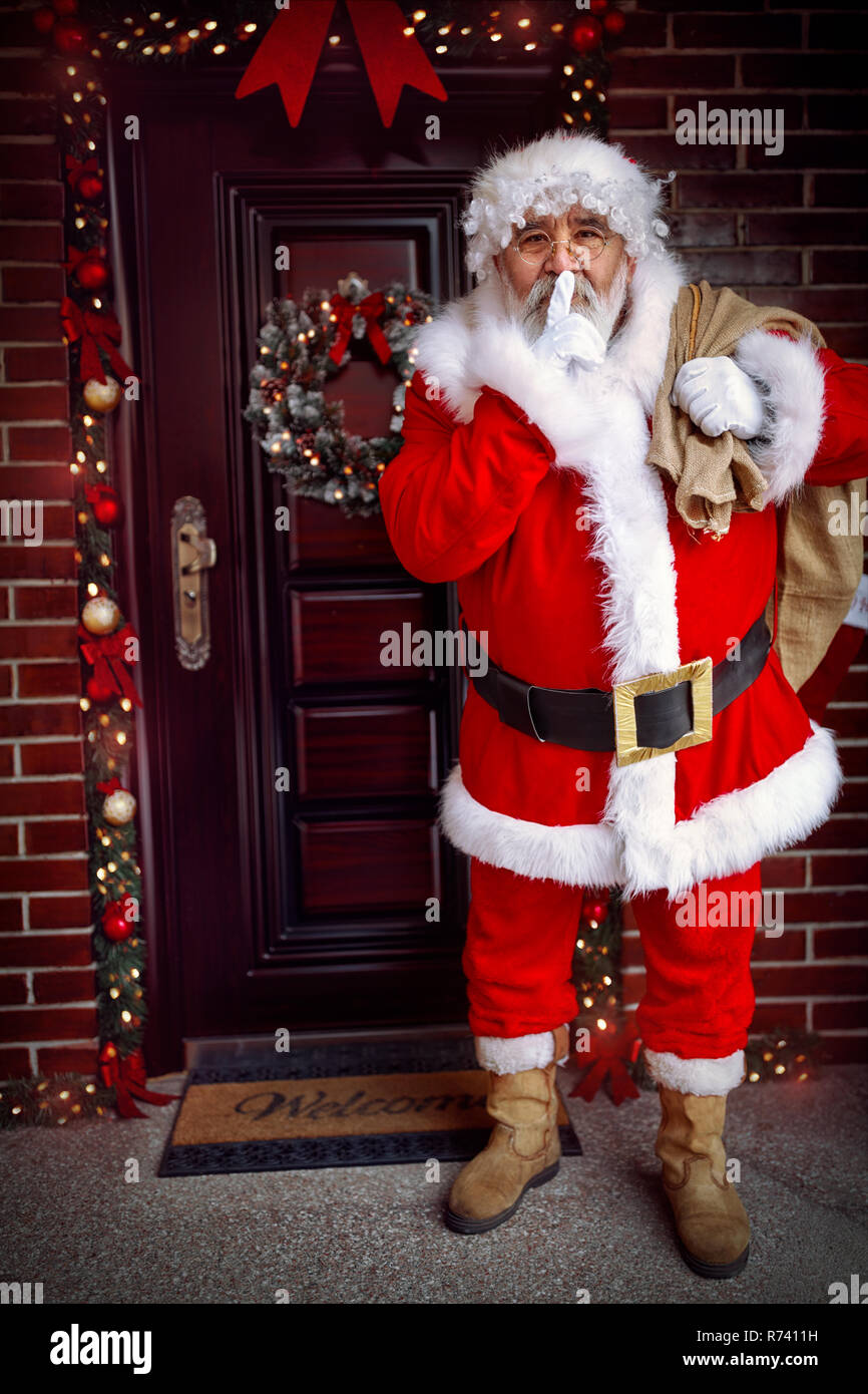 Mantener en secreto- Santa Claus llega con el regalo de Navidad en la noche de Navidad Foto de stock
