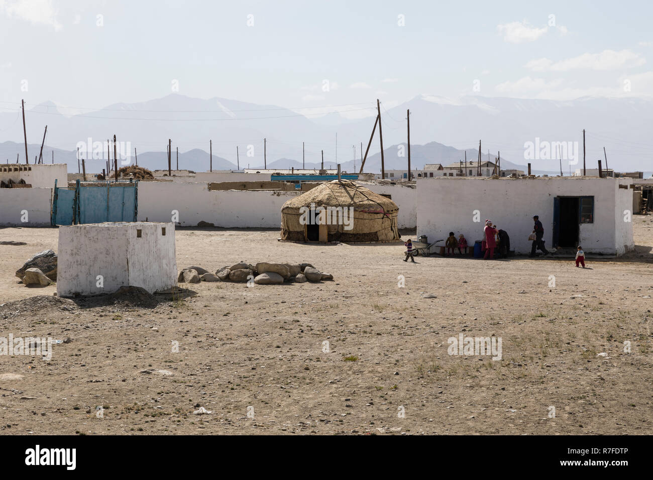 Karakul, Tayikistán, 22 de agosto de 2018: Pequeña ciudad Karakul con una familia delante de su casa. En el medio de la imagen de una yurta, que sirve como un Foto de stock