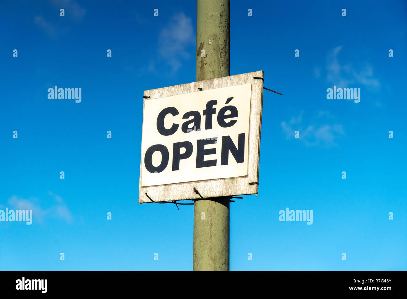 Cafetería abierta signo en poste de metal contra el cielo azul Foto de stock