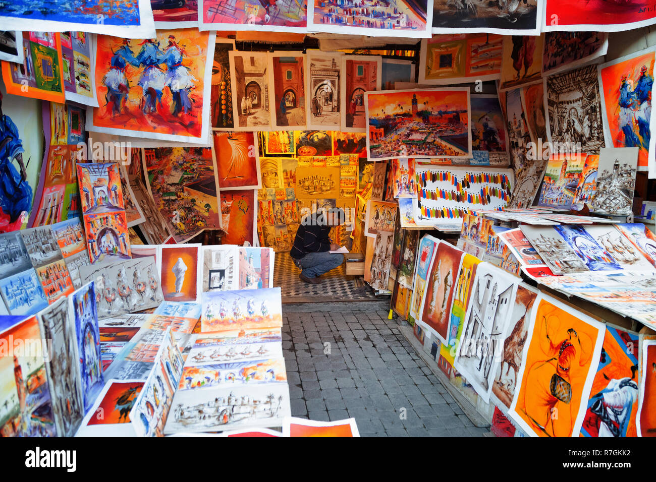 El zoco de Marrakech - un comerciante vende coloridos cuadros y pinturas en un puesto en el mercado en los zocos y la Medina de Marrakech, Marrakech, Marruecos, Norte de África Foto de stock