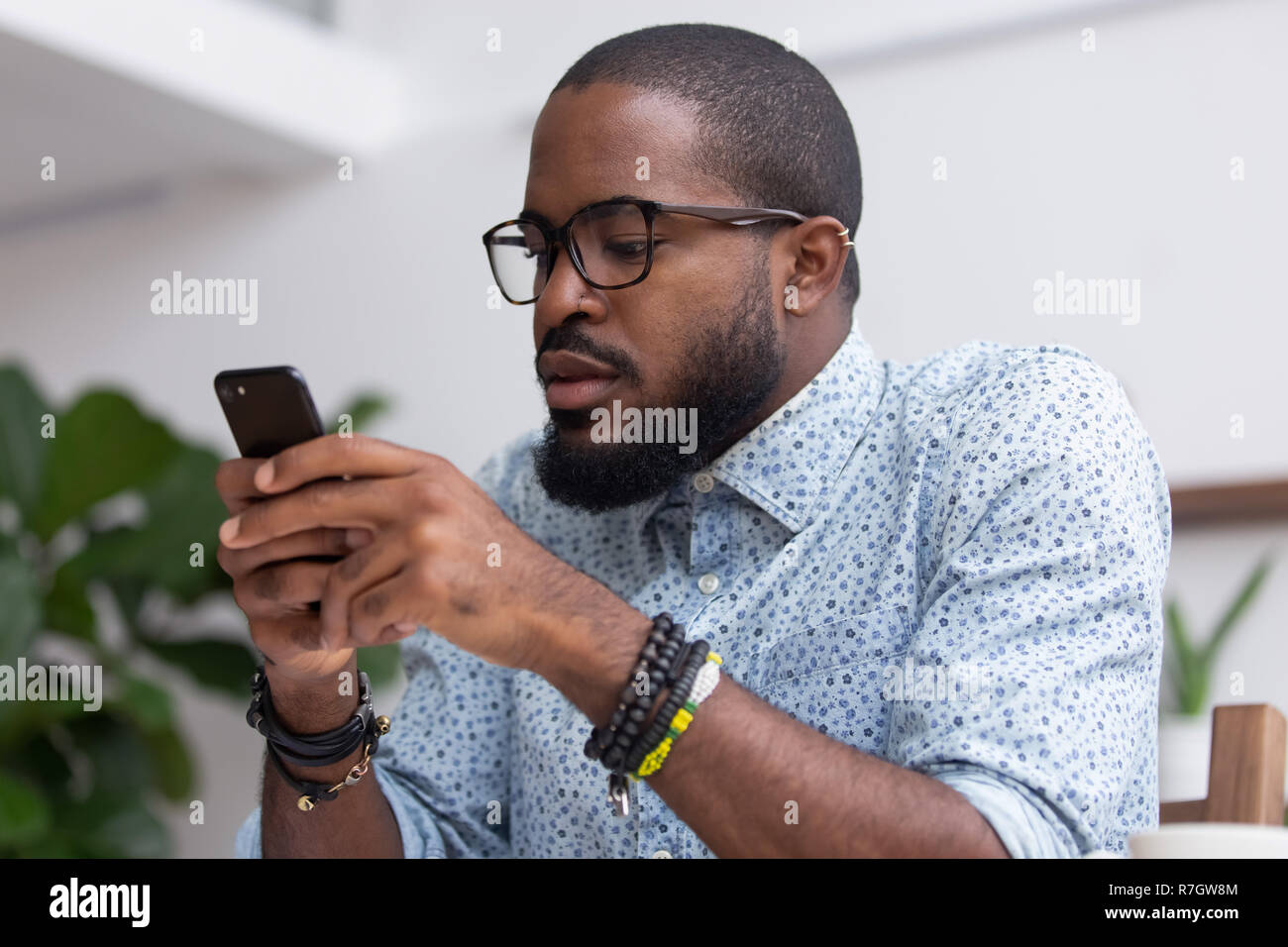 Retrato hombre negro chatear navegar por Internet utilizando el teléfono móvil Foto de stock