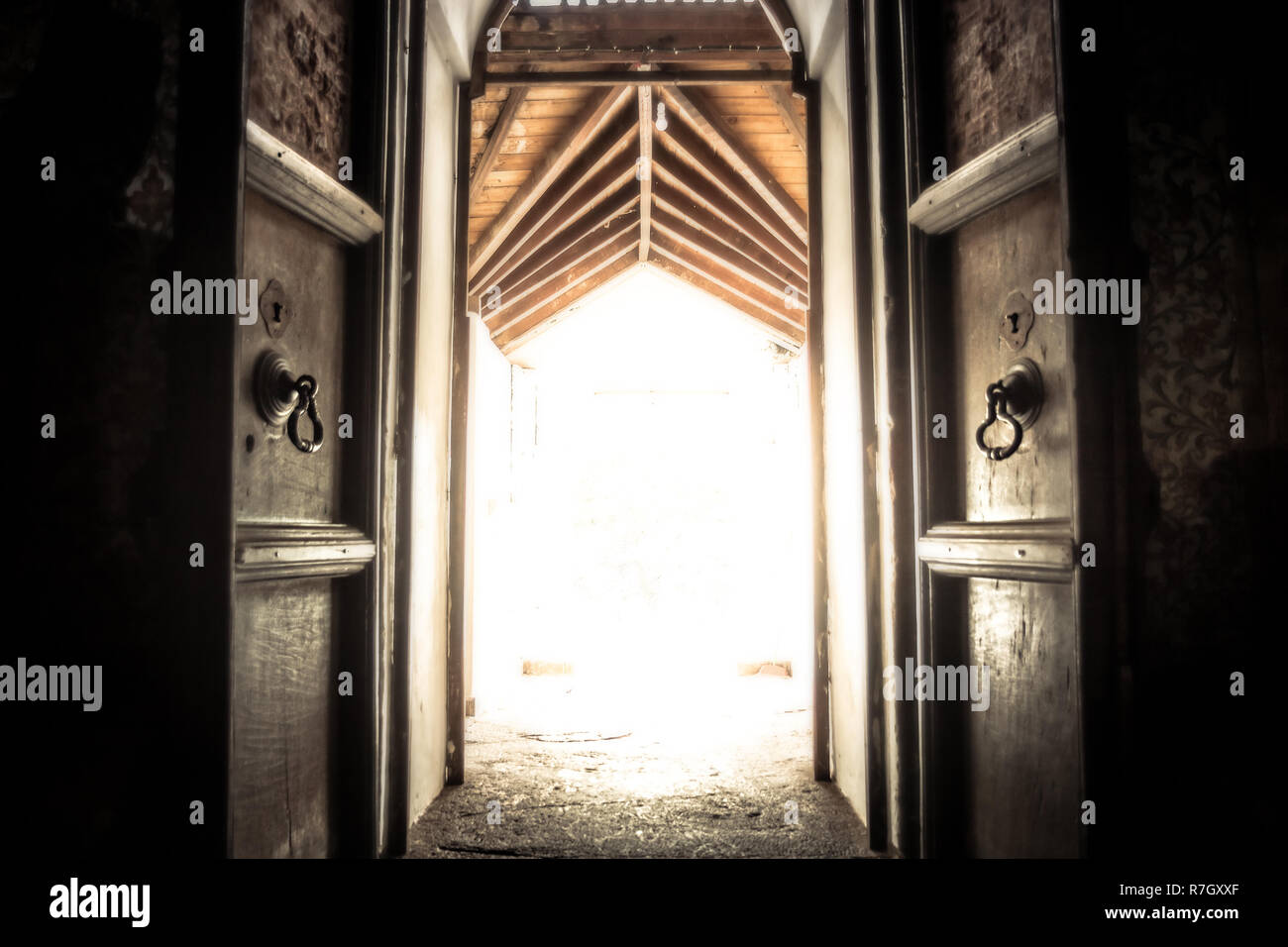 Abrió la puerta del templo antiguo portón con irradiar luz con efecto de luz al final del túnel Foto de stock