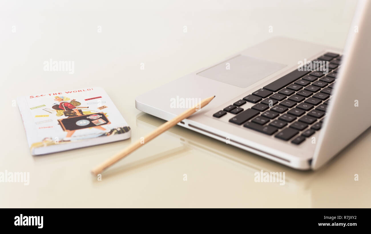 Equipo portátil portátil portátil en la oficina de área de una tabla con un lápiz y un pequeño diario, libro para Freelancer, escritores, fondo blanco. Foto de stock