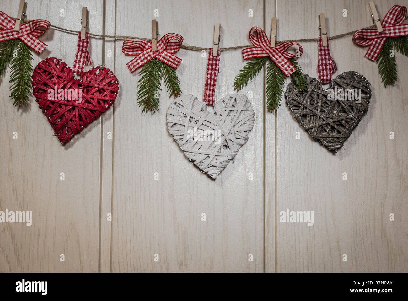Tarjeta de felicitación de navidad con lugar para el texto. Decoración con corazones  colgantes y ramas de abeto sobre fondo de madera Fotografía de stock - Alamy
