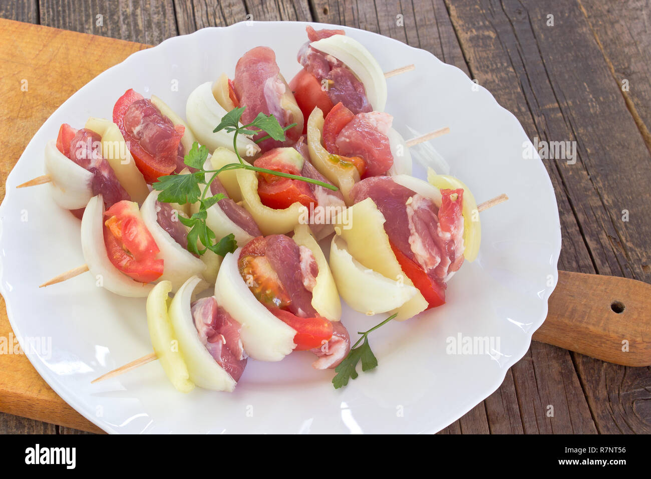 Carne cruda para la rejilla de la placa con las verduras en la placa de corte Foto de stock