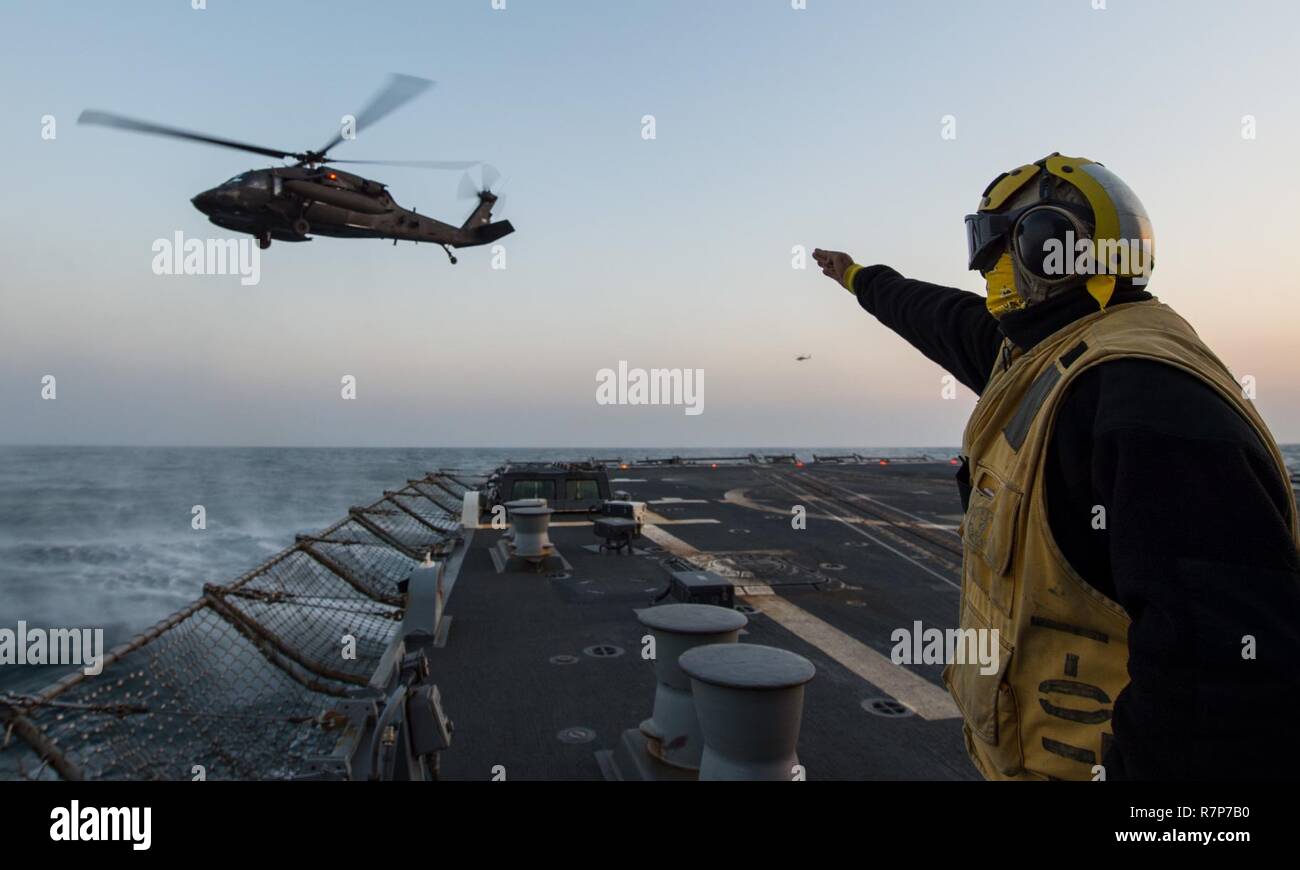 Las aguas al oeste de la península de Corea (Mar. 21, 2017) Boatswain's Mate de 2ª clase de Laurence George Cerezo, asignadas a las desplegadas en la clase Arleigh Burke de misiles guiados destructor USS McCampbell (DDG 85), lleva a cabo las operaciones de vuelo del Ejército de los Estados Unidos con un helicóptero UH-60 Blackhawk como parte del ejercicio Foal Eagle 2017. Foal Eagle 2017 es una serie de eventos anuales de capacitación que están orientadas a la defensa y diseñado para aumentar la preparación para defender a la República de Corea, proteger la región y mantener la estabilidad en la Península Coreana. Foto de stock