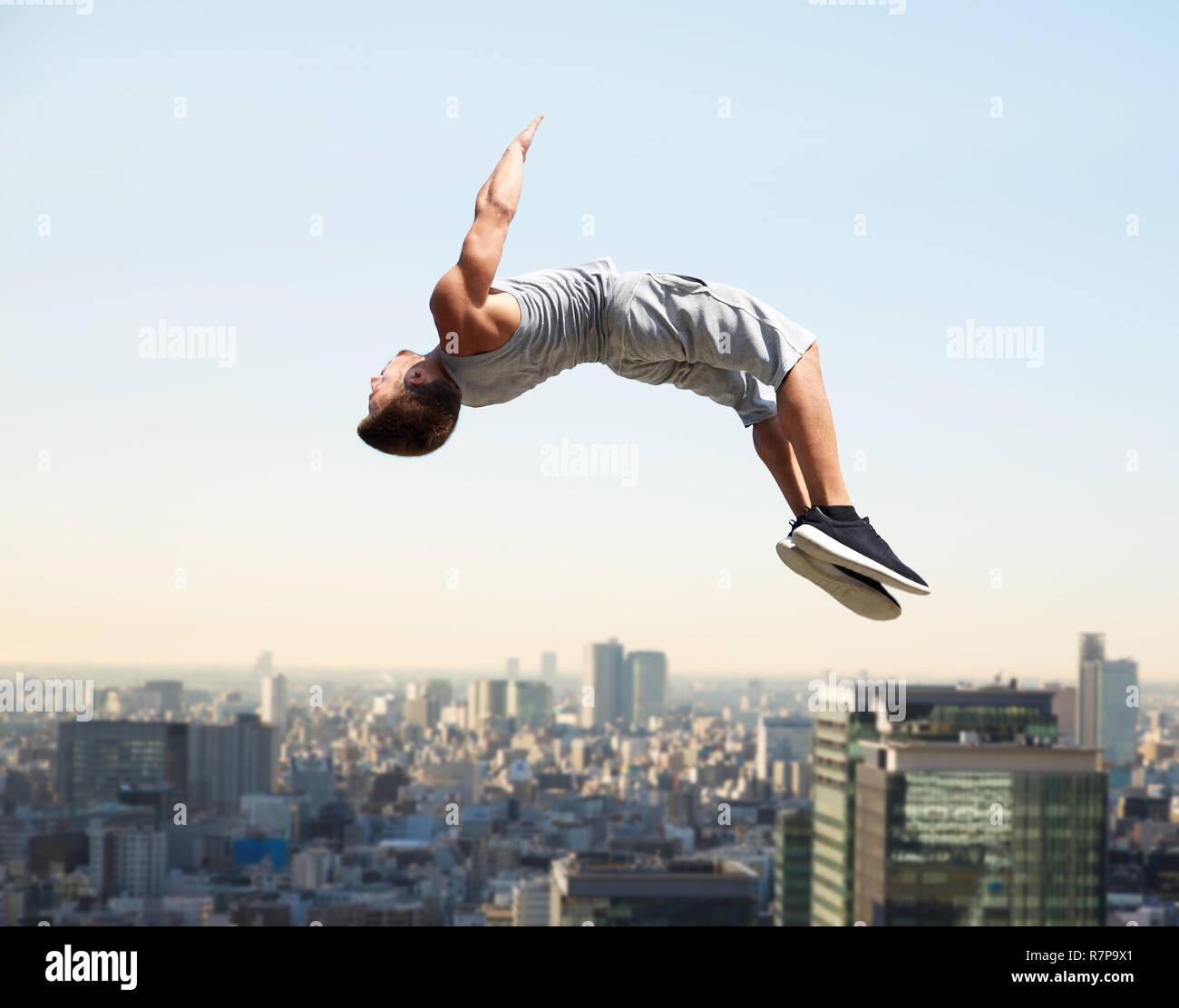 Hombre haciendo parkour saltar por encima de la ciudad de Tokio Foto de stock