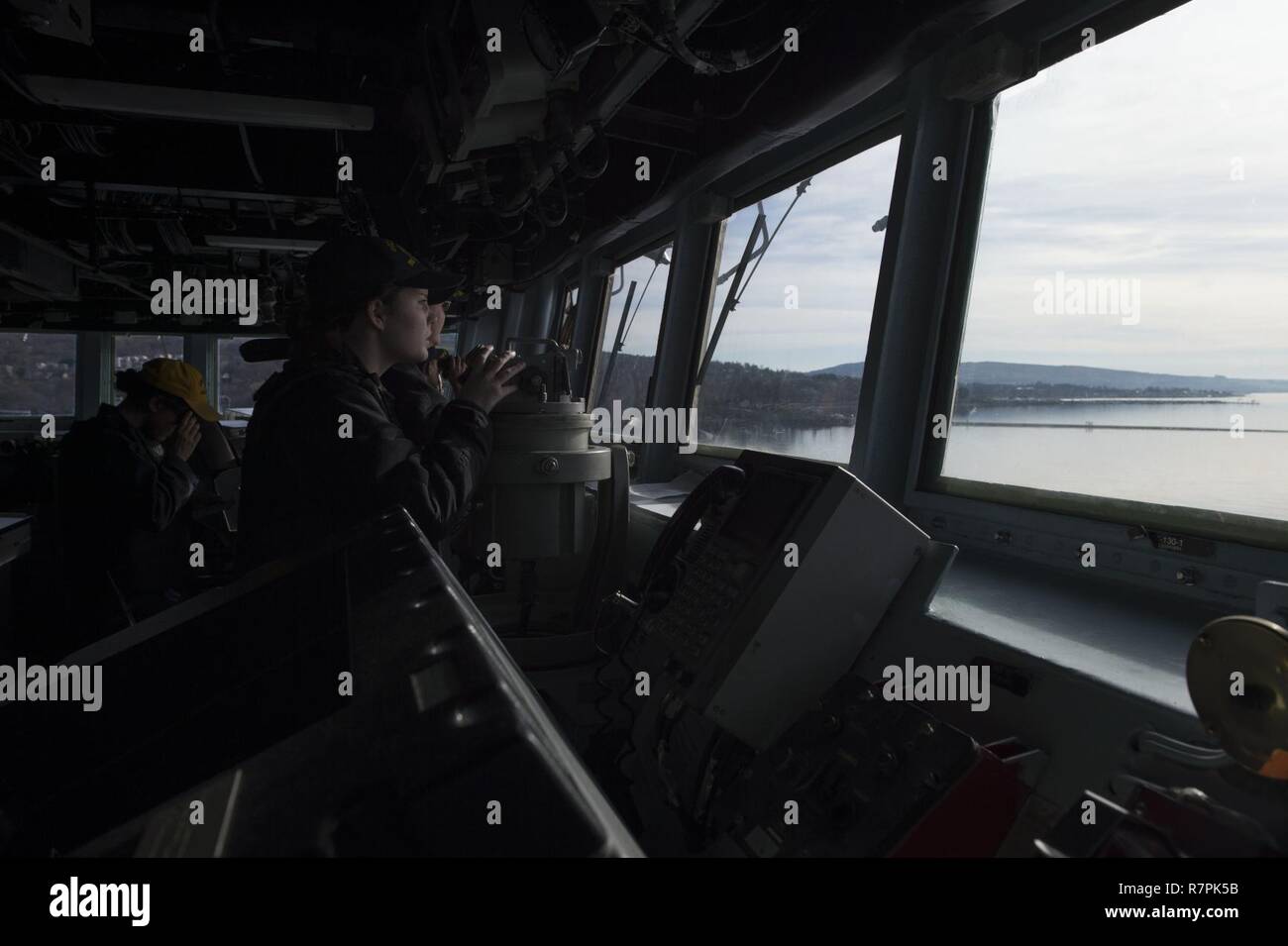 FASLANE, Escocia - (26 de marzo, 2017) - Ensign Rachel vender, conning officer, novillos USS Carney (DDG 64) en marcha de Faslane, Escocia, el 26 de marzo de 2017. Carney, un Arleigh Burke clase destructor de misiles guiados, desplegadas a Rota, España, está realizando su tercera patrulla en los EE.UU. 6ª Flota de la zona de operaciones en apoyo de los intereses de seguridad nacional de EE.UU. en Europa. Foto de stock