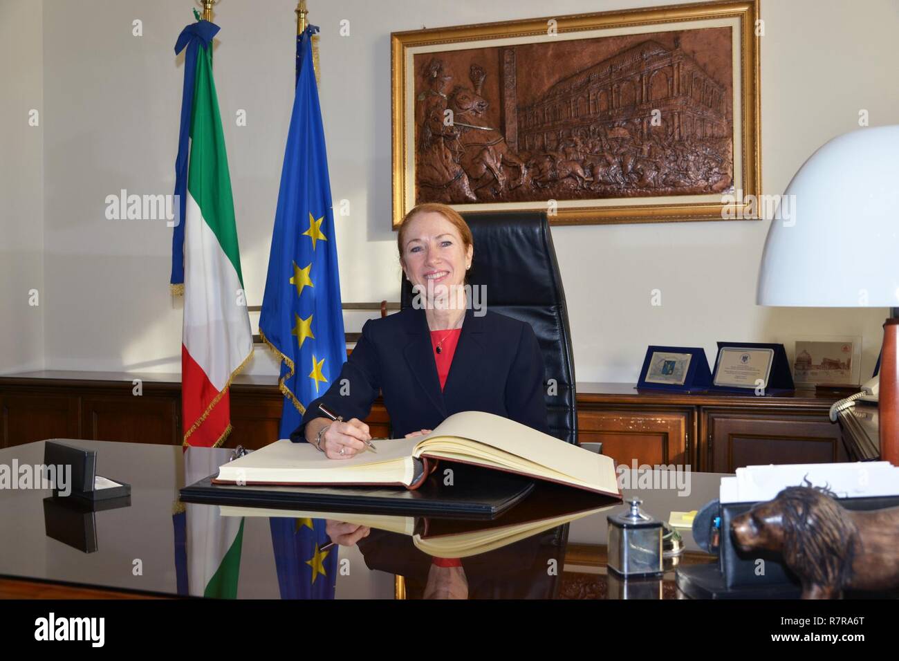La Sra. Kelly Degnan, cargo' d'Affaires ad interim de la Embajada y consulados de Italia, firma el libro de invitados de honor durante la visita al centro de excelencia para unidades de policía de estabilidad (CoESPU) de Vicenza, Italia, el 30 de marzo, 2017. Foto de stock