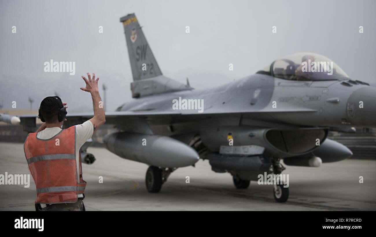 El Sargento. Ryan, el mejor de los casos, 455Expedicionaria Escuadrón de Mantenimiento de aeronaves de carga de armas miembro de la tripulación, y el Teniente Coronel Craig Andrle, 79º comandante de escuadrón de combate expedicionario, show de garras de tigre, que representa a la mascota del escuadrón de caza, después de una incursión de combate el 20 de marzo de 2017 en el aeródromo de Bagram, Afganistán. Andrle alcanzó un hito 1.000 horas de combate mientras sujeta la aleta de contraterrorismo de la misión en Afganistán. Foto de stock