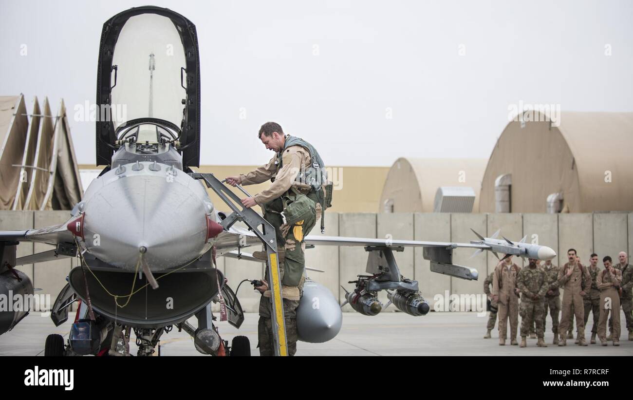El Teniente Coronel Craig Andrle, 79º comandante de escuadrón de combate expedicionario, trepa hacia abajo desde un F-16 combates Falcon como miembros de la 79ª EFS esperar para felicitarle por su vuelo 1.000ª hora de combate, el 20 de marzo de 2017 en el aeródromo de Bagram, Afganistán. Andrle alcanzado el hito mientras sujeta la aleta de contraterrorismo de la misión en Afganistán. Foto de stock