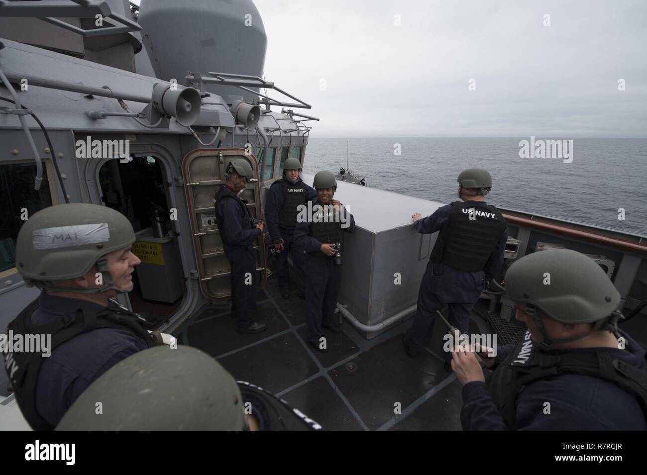 Océano Atlántico - (Marzo 31, 2017) - Los miembros de la pequeña acción CRAFT y miembros del equipo náutico del buque u otro equipo de examen de inteligencia fotográfica impartir capacitación sobre el puente ala a bordo del USS Carney (DDG 64) durante el ejercicio Joint Warrior 17-1 del 31 de marzo de 2017. Carney, un Arleigh Burke clase destructor de misiles guiados, desplegadas a Rota, España, está realizando su tercera patrulla en los EE.UU. 6ª Flota de la zona de operaciones en apoyo de los intereses de seguridad nacional de EE.UU. en Europa. Foto de stock