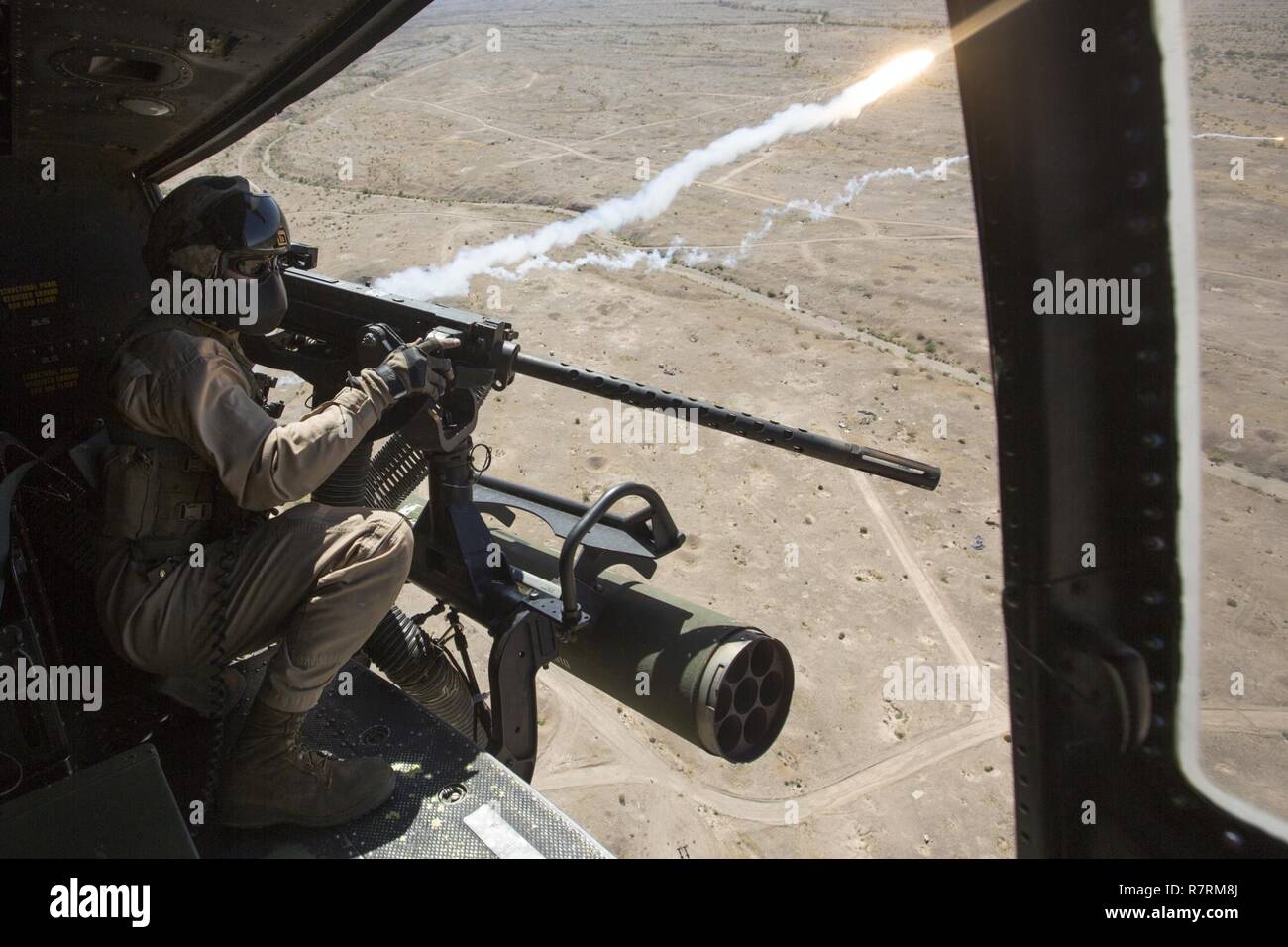 Cuerpo de Marines de EE.UU Cpl. Justin Gilstrap, un jefe de la tripulación con Luz Marina 167 escuadrón de helicópteros de ataque (HMLA-167), desencadena un GAU-21 calibre .50 ametralladora durante la artillería aérea perforadoras de refinamiento en chocolate Antena Montaña Tiro, California, 5 de abril de 2017. Armas y tácticas Instructor 2-17 es un evento de capacitación de siete semanas organizado por la Aviación Marina armas y tácticas de escuadrón MAWTS Uno (cuadro 1). Foto de stock