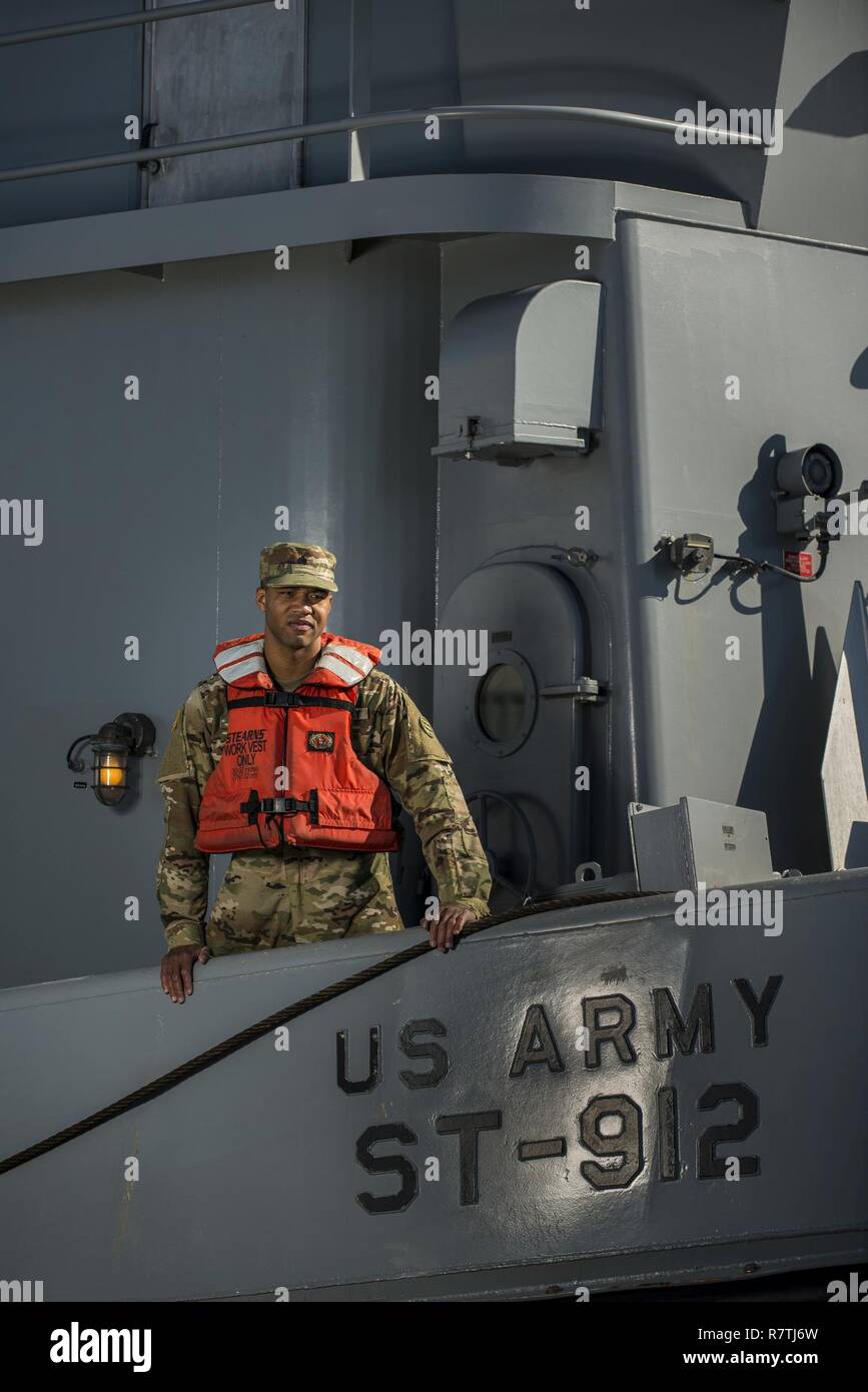 El Sgt. Antoine Cooper, una Reserva del Ejército de EE.UU. Operador de embarcaciones soldado con la 949ª Compañía de transporte, plantea en un buque del Ejército por una serie de retratos que representan su ocupación militar especialidad en Baltimore, Maryland, en abril 7-8, 2017. Foto de stock