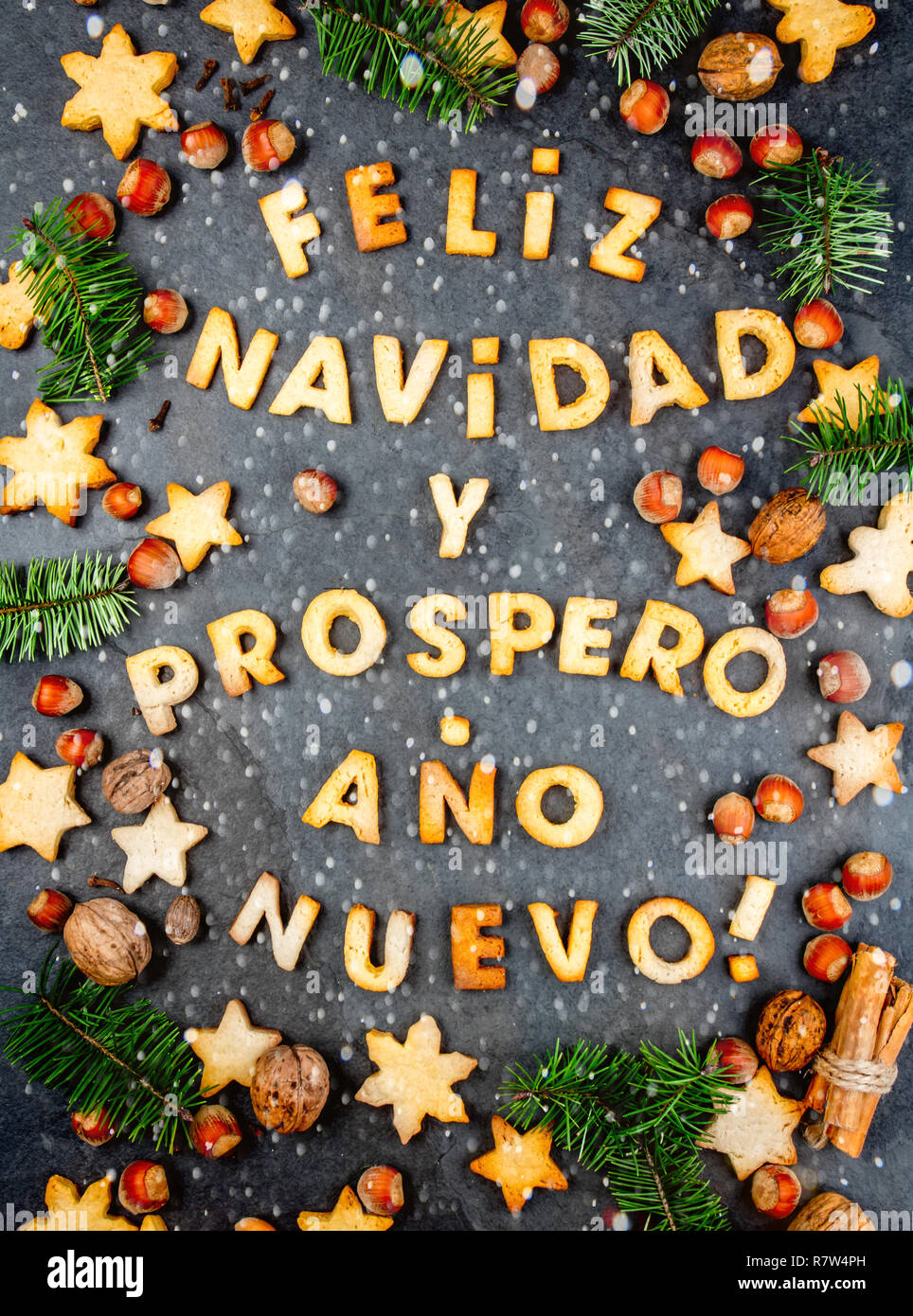 FELIZ NAVIDAD COOKIES. Palabras texto Feliz Navidad y Feliz Año Nuevo en  Español con galletas, decoración de Navidad y las tuercas en el fondo de  pizarra negra. Tarjeta de Navidad para los