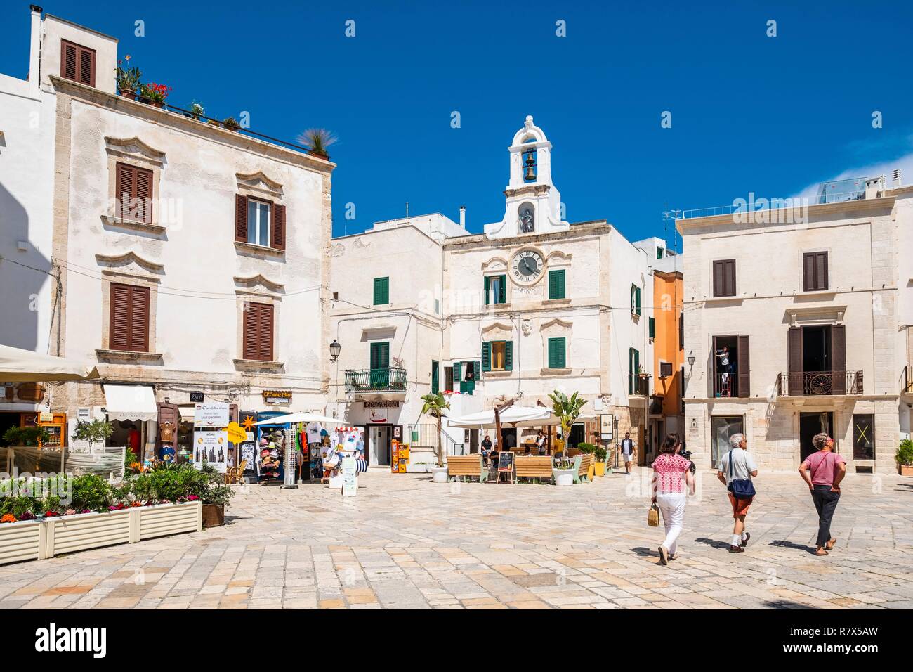 Italia, Apulia, Polignano a Mare, el centro histórico de la ciudad se alza sobre un acantilado de piedra caliza con vistas al Mar Adriático, en la plaza Vittorio Emanuele II y la torre del reloj Foto de stock